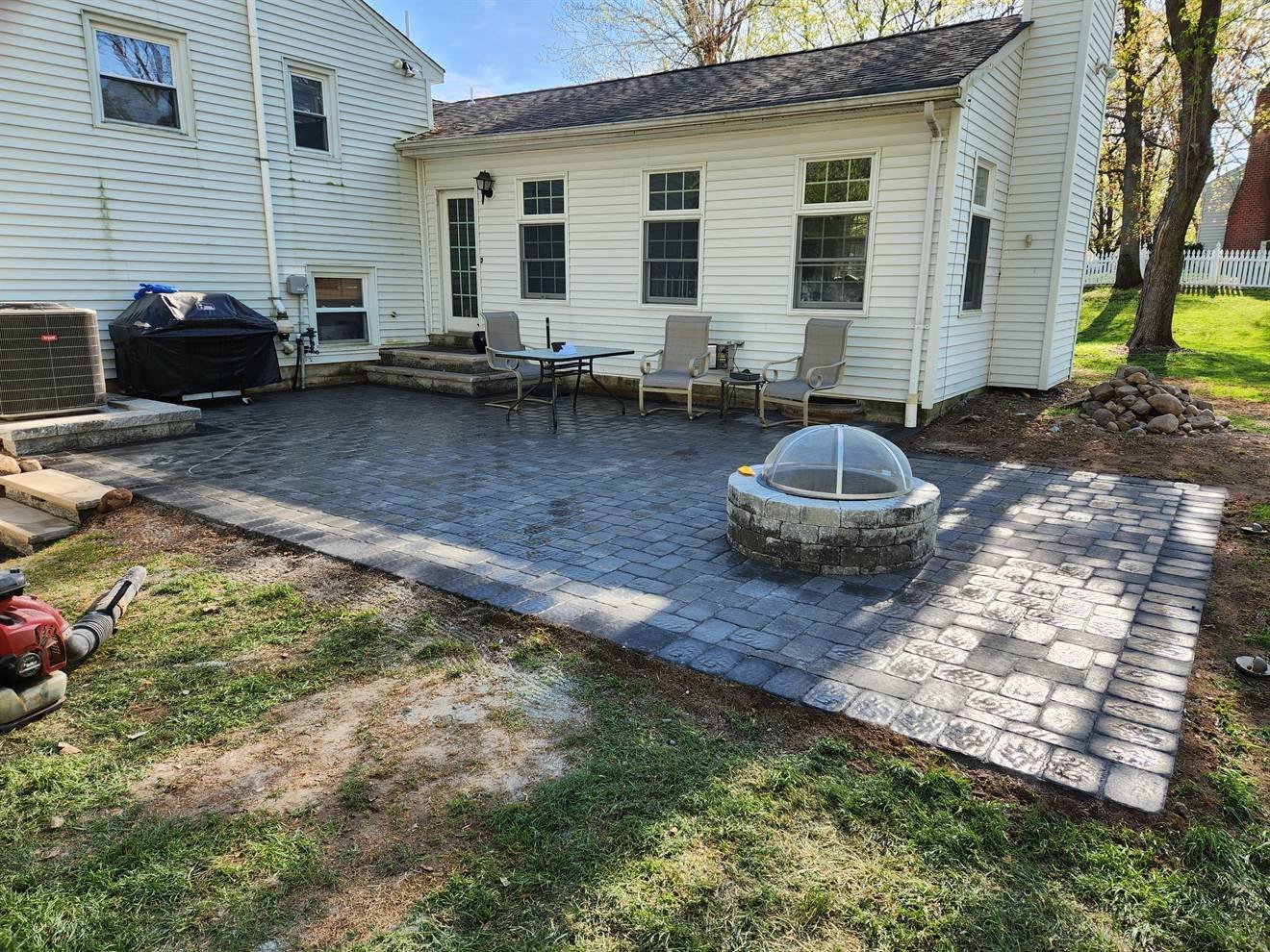 Completed curved paver patio with a circular fire-pit area