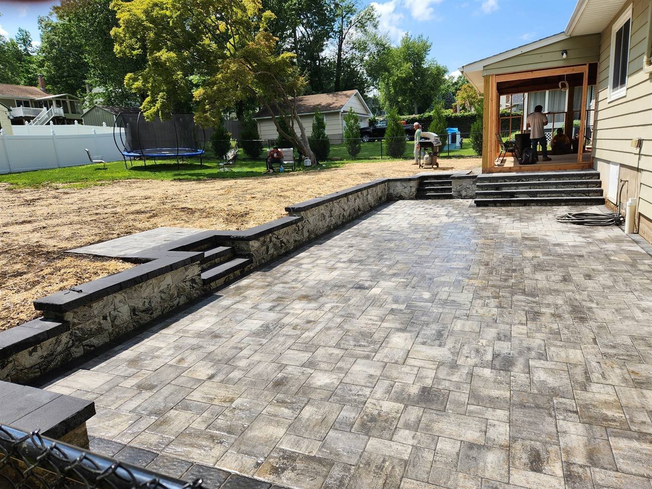 Completed raised paver patio with steps and low wall