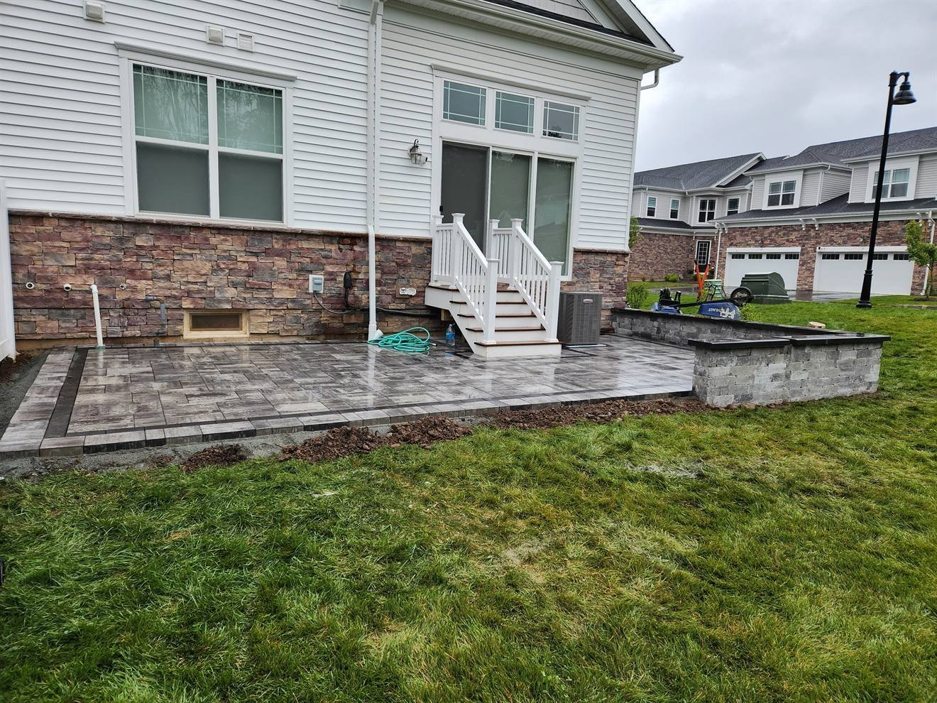Raised paver patio supported by a retaining wall