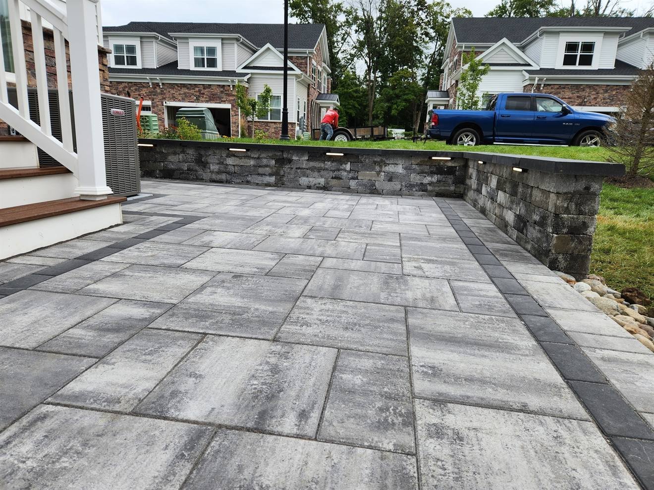 Large-format paver patio with retaining wall and dark border