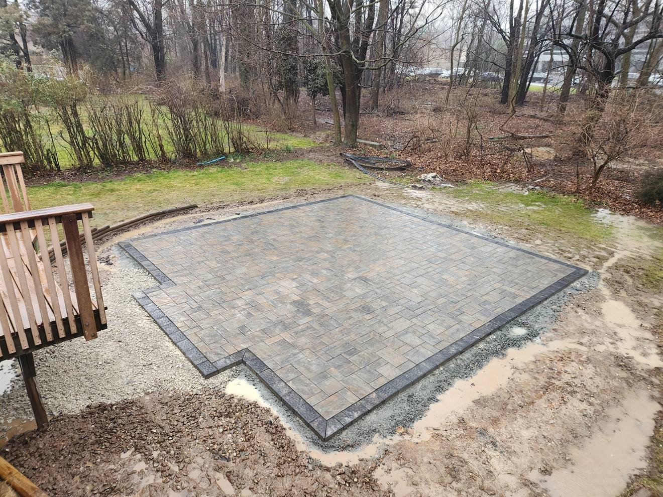 Completed rectangular paver patio in a wooded backyard
