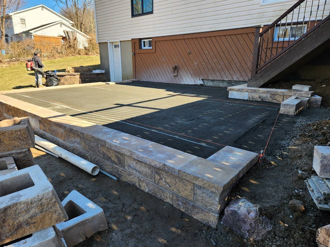 Paver surface being installed above the retaining wall