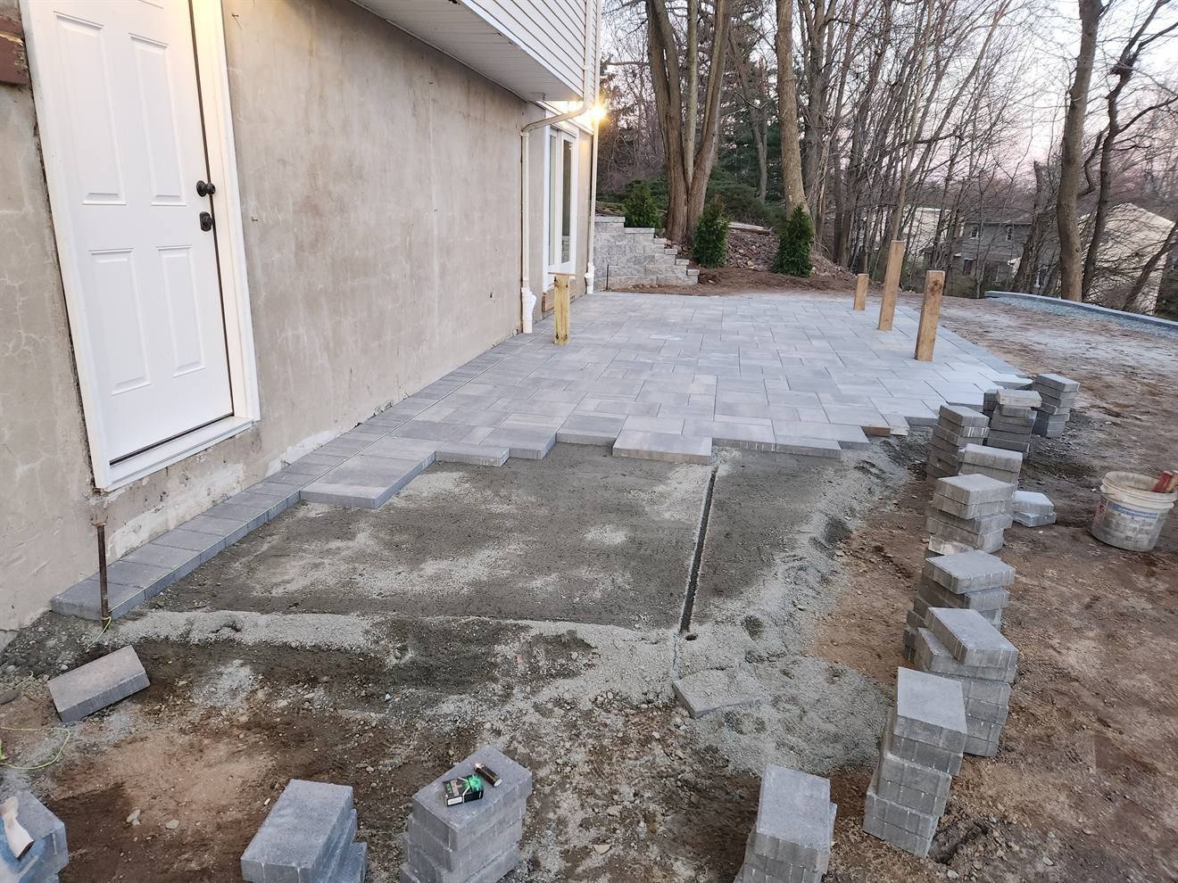 Paver field progressing across the prepared patio base