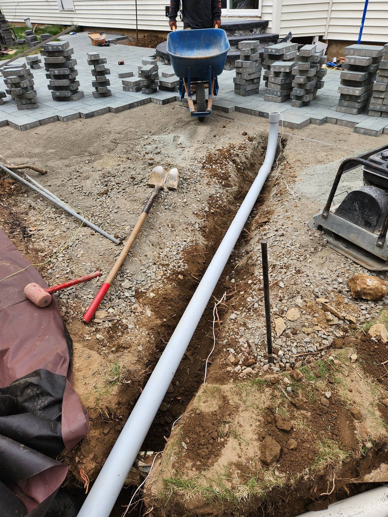Drainage line installed beside the prepared patio area