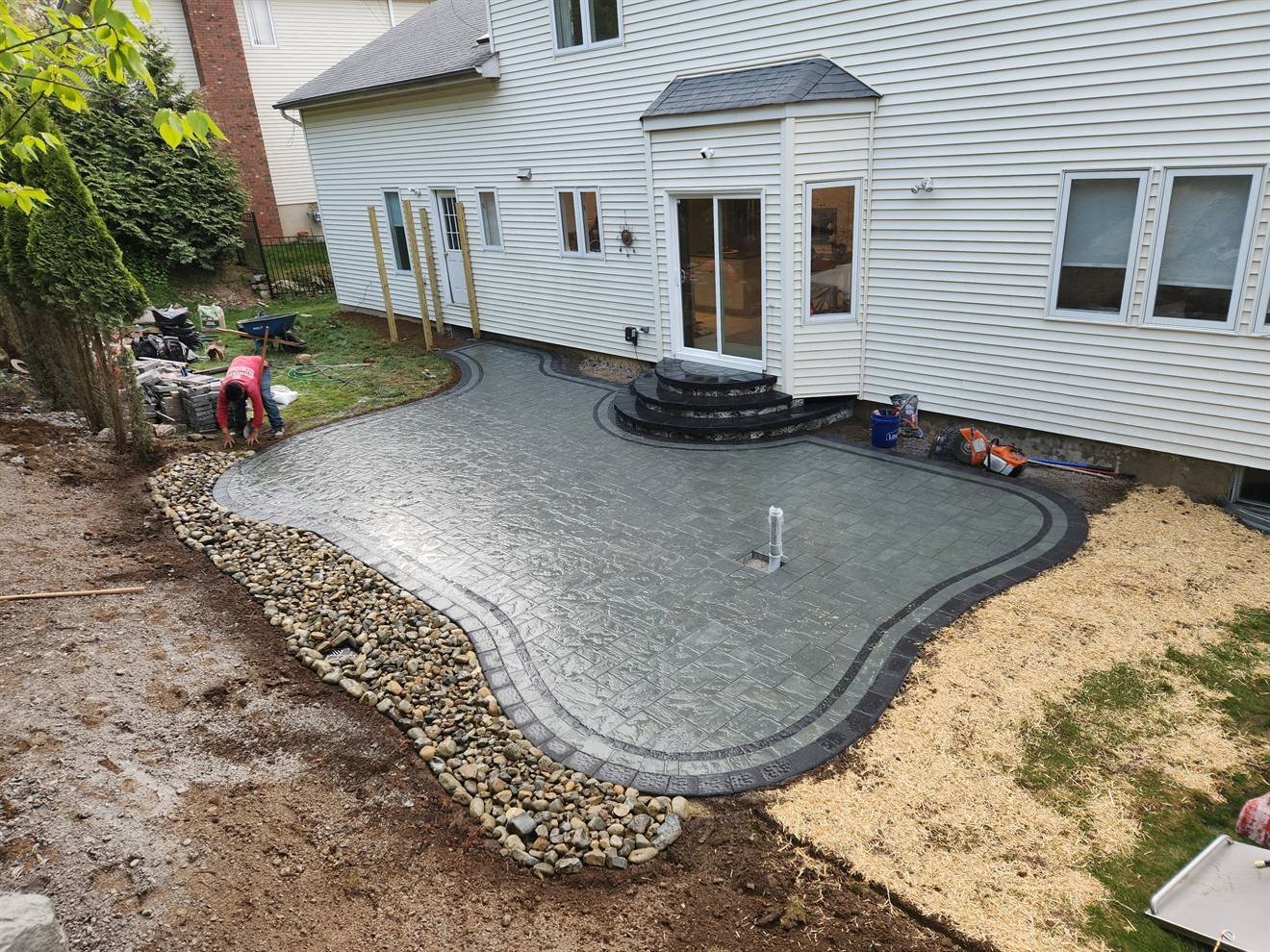 Finished curved patio with contrasting border and stone drainage edge