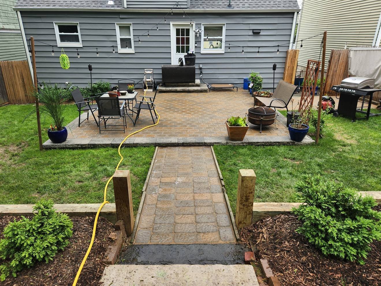 Completed paver walkway leading to a backyard patio