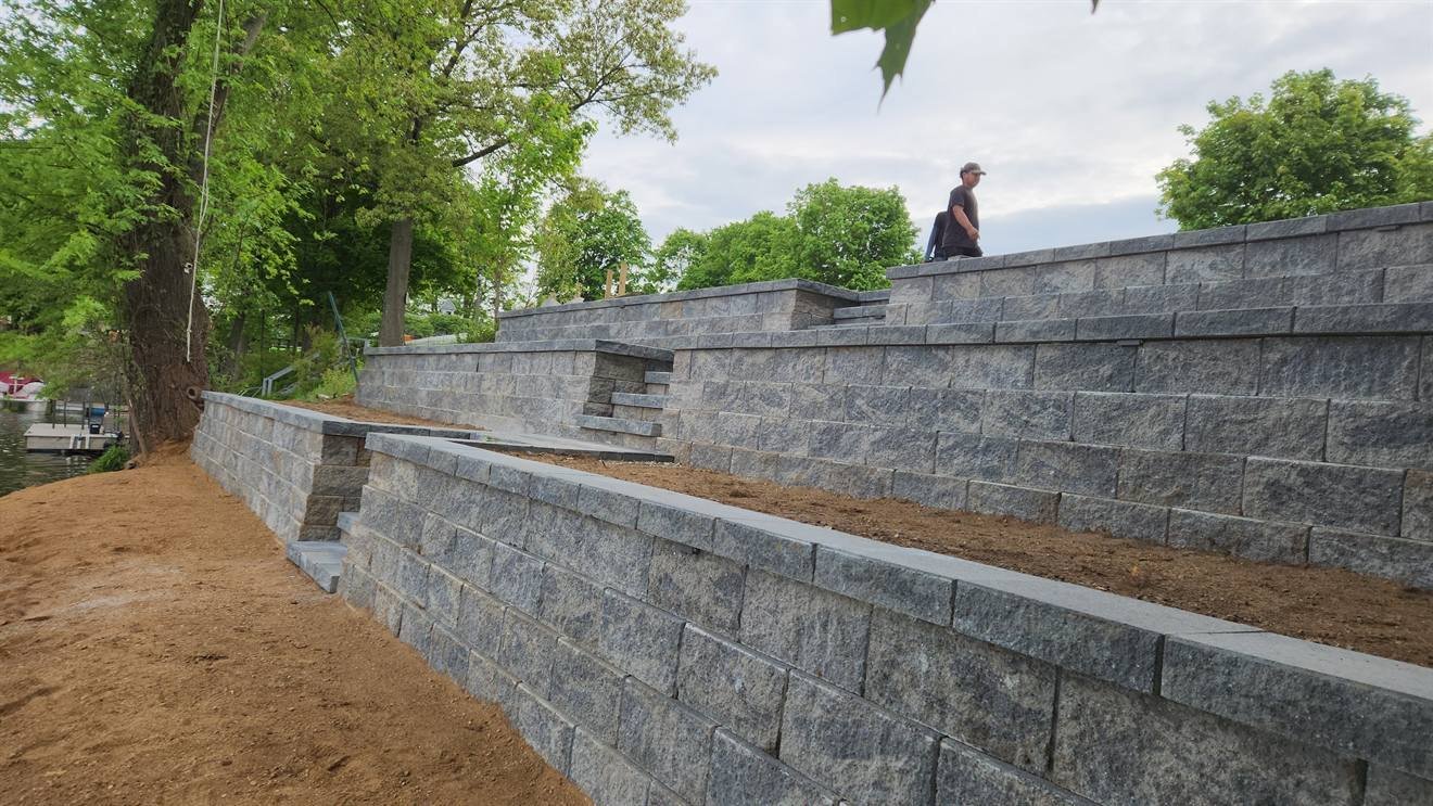 Completed tiered retaining wall beside a lake