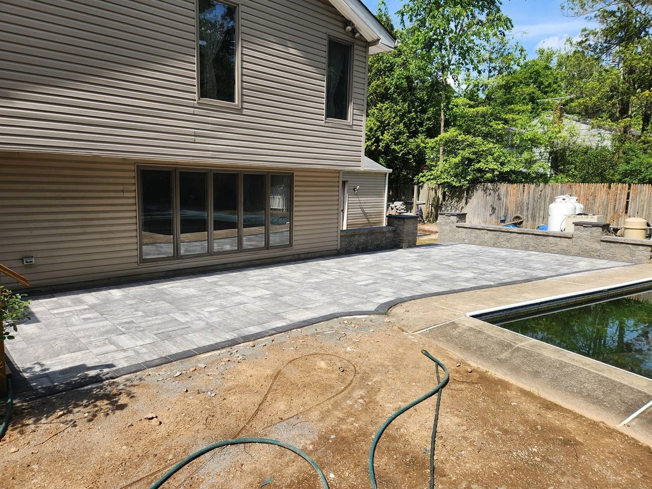 Large paver patio installed beside a home