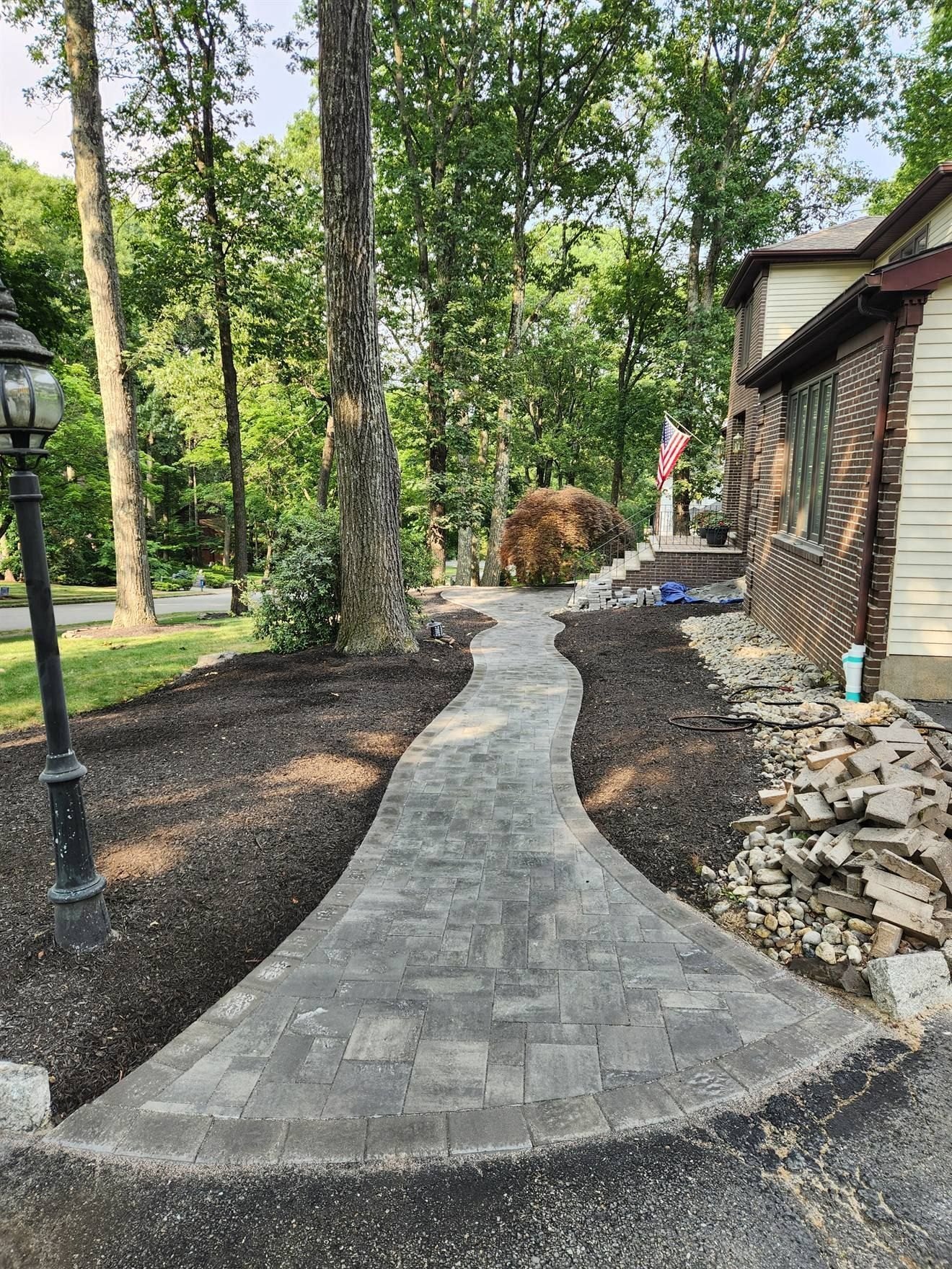 Curved paver walkway through a landscaped side yard